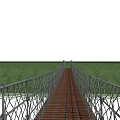 Scenic Suspension Landscape Bridge With Wooden Deck Metal Railings Green Grass And White Sky