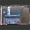 Blue Genie GS-3246 Scissor Lift Industrial Equipment on Red Ground with Orange Traffic Cones