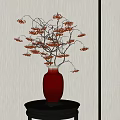 Red Vase With Branches Bearing Red Berries On Black Stand Against Light Wall