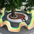 Colorful Wavy Outdoor Chair Design for Leisure Area Under Big Tree with Stone Pavement