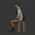 Man In Gray Turtleneck Sitting On Stool With Orange Pants Black Boots And Dark Coat