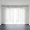 White Curtains Covering Full Window in Room With White Walls and Dark Wooden Floor