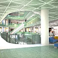 Modern Shopping Mall Lobby With Glass Staircase Open Layout Bright Lighting And Seating Areas