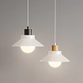 Modern Pendant Lights with White Shades Black and Wooden Bases Illuminated on Gray Wall