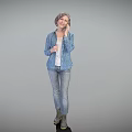 Elderly Woman In Blue Printed Jacket And Jeans Standing Against Gray Background