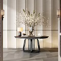 Modern Console Table With Round Tabletop White Blossom Vase And Wall Sconces Against Textured Wall