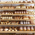 Assorted Freshly Baked Bread Loaves Rolls And Sticks On Wooden Bakery Shelves