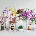 Floral Art Display With Various Colorful Blooms In Vases And Pedestals With Scattered Petals