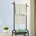Black Metal Clothes Rack with Hanging Checkered Towels and Potted Plant