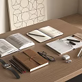 Open Brown Notebook and White Notebooks with Eyeglasses Watch Pencils Earbuds on Wooden Desk