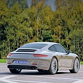 Silver Sports Car Parked in Open Area With Paved Ground and Green Trees