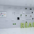 Pegboard Wall Decor With White Shelves Green Plants And READ Letters
