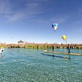 Scenic Park Landscape With Clear Water Swans Wooden Pier Hot Air Balloons Reeds And Pavilion