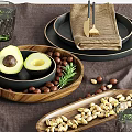 Stylish Dinnerware Set Including Plates Napkins Cutlery Avocado Nuts Glasses Vase Greenery on Linen Placemat