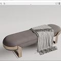 Gray Upholstered Ottoman With Gold Metal Legs And Striped Throw Blanket