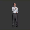 Man in light blue shirt and dark pants gesturing with right fist against gray background