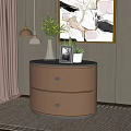 Beige Two Drawer Bedside Table With Circular Top Blue Vase Green Plants Photo Frame Potted Plant
