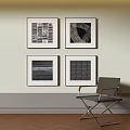 Modern Single Chair With Metal Frame Armrests Against Light Wall And Four Framed Artworks