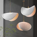 Modern White Pendant Lights With Wavy Texture And Gold Accents In Indoor Space With Plants