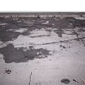 Damaged Asphalt Pavement With Visible Cracks And Potholes On Surface