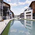 Modern Commercial Street With Water Canal Buildings Shops Outdoor Seating And Greenery Reflections