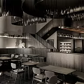 Modern Café Interior With Spiral Black Chandeliers Curved Seating Tables Chairs And Staircase