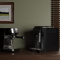Silver And Black Espresso Coffee Machines On Wooden Countertop With Green Wall