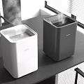 Two Modern Electric Humidifiers White And Black For Home Office Use On Table