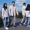 Couple Holding Hands in White Tops and Jeans with Green Bushes and Blue Sky