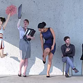 Group of People Standing and Sitting by Concrete Wall With Cheerleader Pom Poms Briefcase Folders