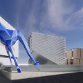 Vibrant Commercial Street Featuring Giant Blue Bear Sculpture and Pedestrians Near Modern Buildings