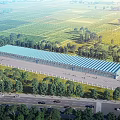 Large Industrial Factory Building With Blue Roof In Open Green Fields And Trees