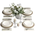 Elegant Dinnerware Set With White Plates Woven Placemats Cutlery Wine Glasses And Floral Vase