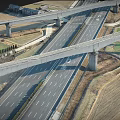 Aerial View Of Interchange Bridge With Multiple Roads Intersecting And Farmland Below