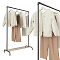 Stylish Beige Knit Sweaters With Brown Pants Hanging On Metal Clothing Rack