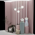 Modern Pink Window Display with Striped Decor Mannequin White Dress Cylindrical Pedestals and Green Plants