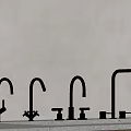 Modern Stainless Steel Kitchen Faucets Display On Concrete Countertop With Gray Wall