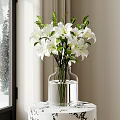 Transparent Glass Vase with White Lilies on Small Patterned Table by Window with Snowy Scenery