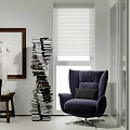 Modern Living Room Interior With Cozy Purple Upholstered Armchair And Artistic Tall Stacked Book