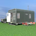 Green Trailer With Open Door Parked Near 4x4 Vehicle Folding Table Red Chairs On Grass