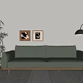 Green Leather Three-Seat Sofa with Wooden Legs Black Floor Lamp Wall Art and Potted Plant