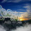 Wave Shaped Cloud Pattern Art Installation With Blue Sky White Clouds Green Mountains Grass Field