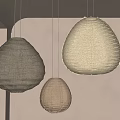 Three Teardrop Shaped Natural Woven Rattan Pendant Lights Hanging In Interior Space