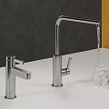 Modern Stainless Steel Kitchen Faucet With Water Flowing And Marble Object On White Countertop