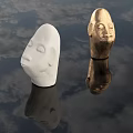White And Golden Head Sculptures With Carved Facial Features And Water Reflections