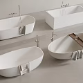 Various Shaped White Bathtubs With Faucets And Gray Towels On Gray Floor