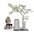 Glass Vase with Green Leafy Branch and Decorative Figure on Tabletop