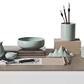 Light Green Ceramic Desk Items With Brushes Notebook And Mountain Decor On Wooden Table