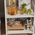 White Rolling Kitchen Shelf With Decorative Items Combination Glass Jar Books Pear On Wooden Floor
