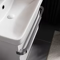 Wall Mounted White Washbasin with Round Backlit Mirror Orange Towels Side Table Toiletries and Plant